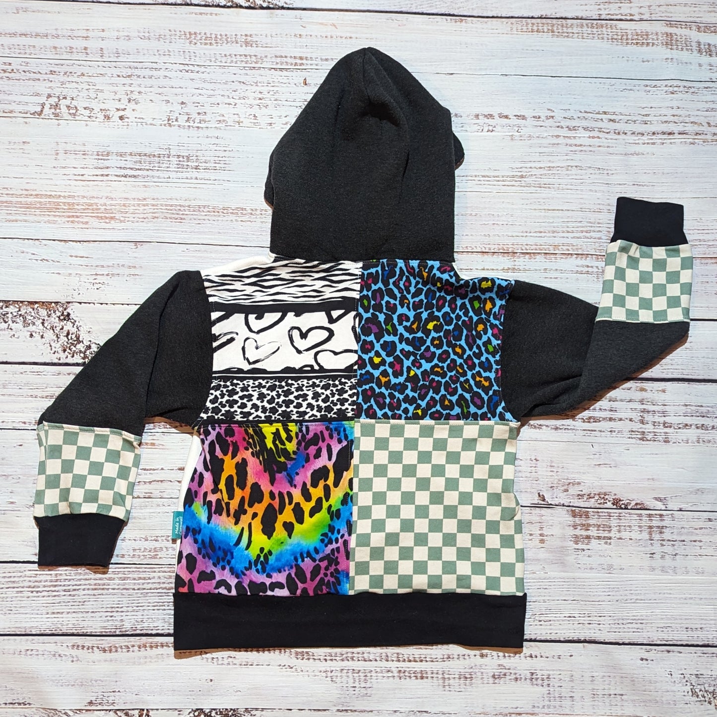 Rear view of the mint checked and colourful animal print hoodie. With a stunning patchwork of neon animal print, neon leopard print, animal hearts and mint checked on a charcoal hoodie.