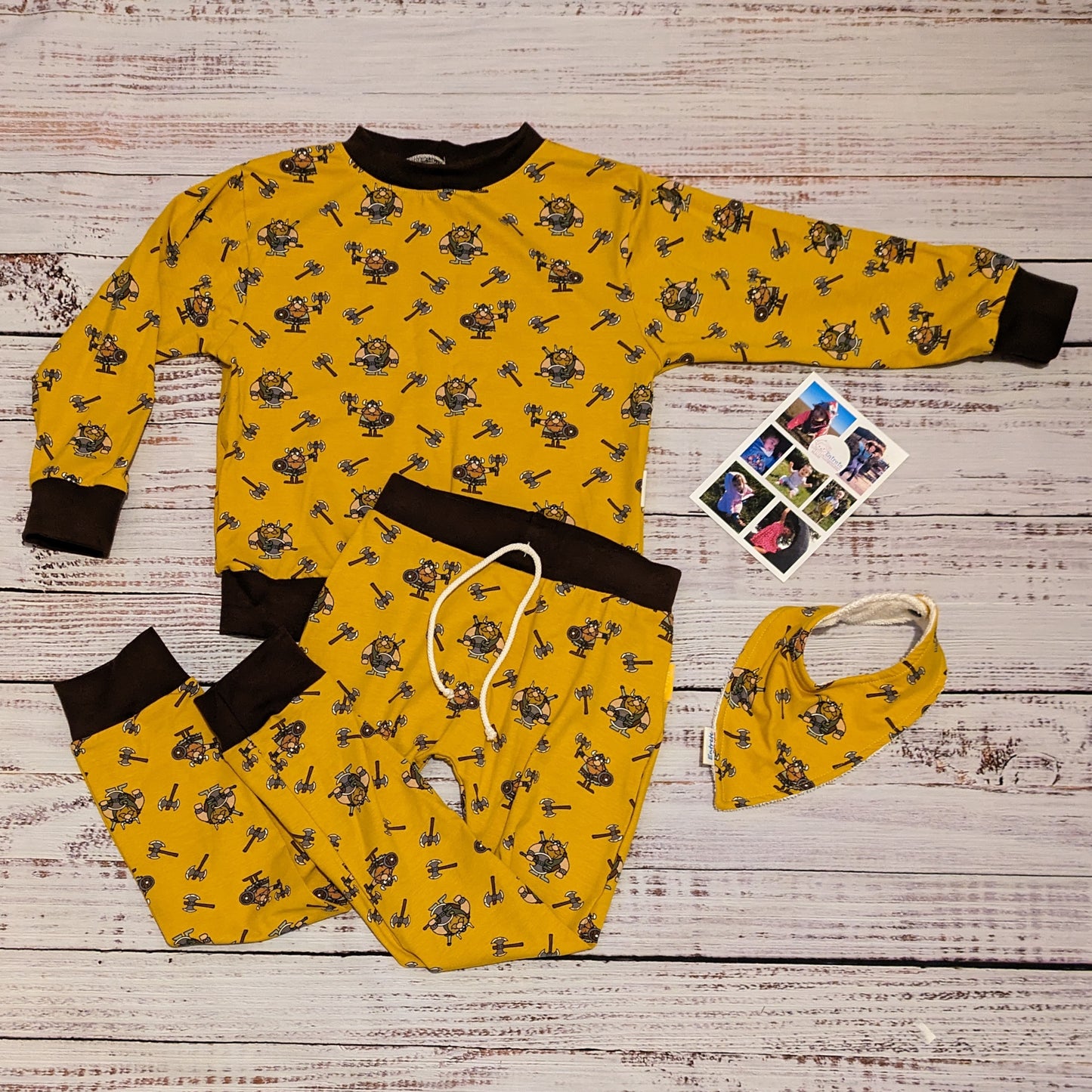 The fun mustard Vikings and chocolate unisex kids sweatshirt. Handmade using mustard Vikings cotton jersey and chocolate cotton ribbing. Shown as a set with matching harem joggers and bamboo bib.