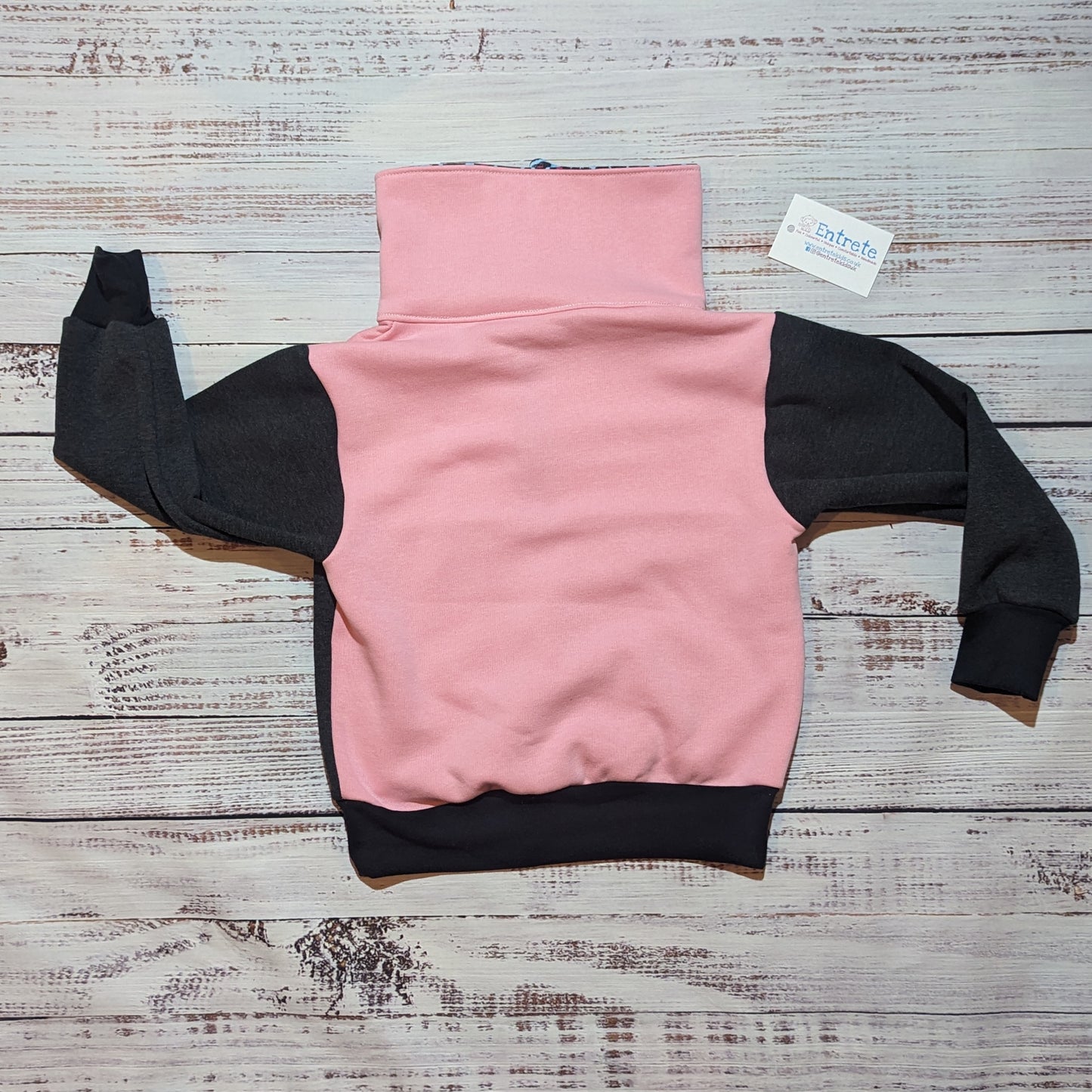 Rear of the neon leopard print sweatshirt. With pink body and collar and charcoal arms.