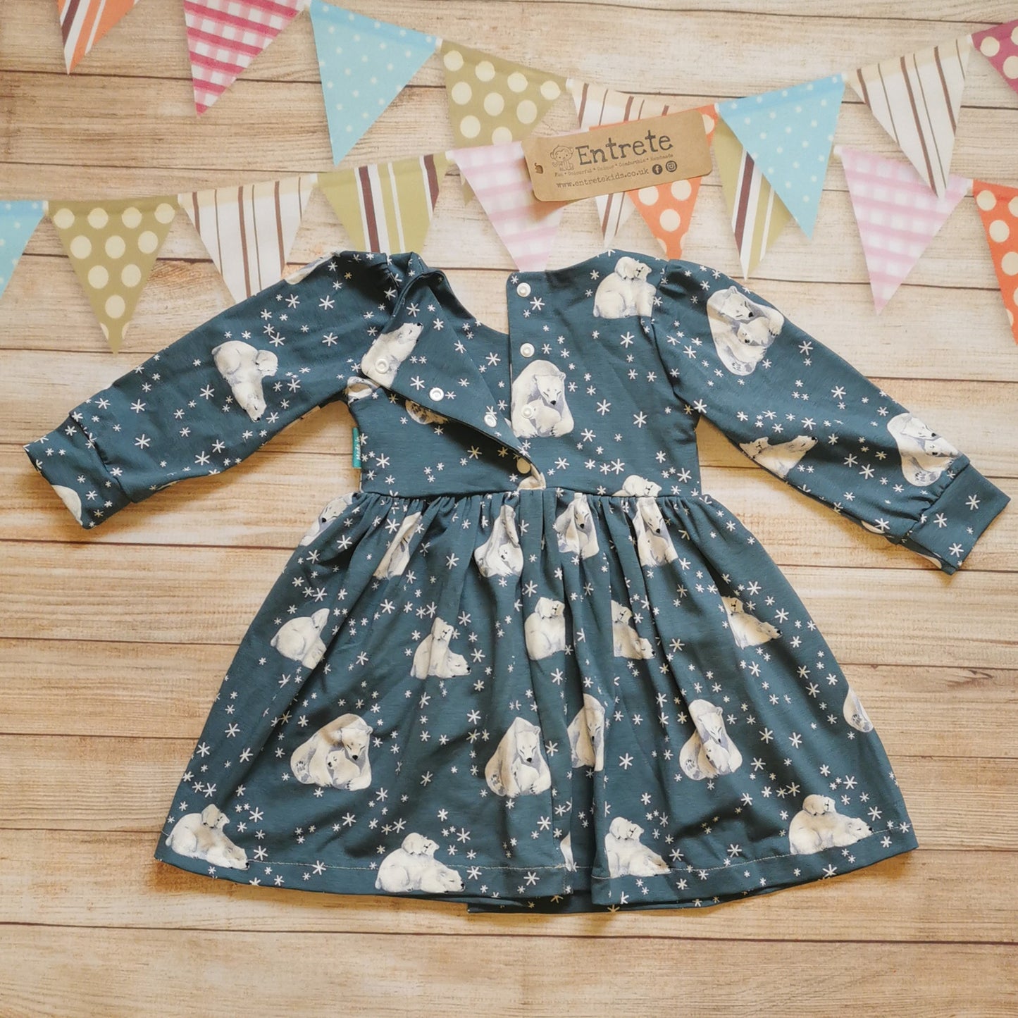 Rear of girls Christmas dress, handmade using the gorgeous dusty blue polar bears cotton jersey. With poppers used in dresses over 9-12 months, smaller sizes have poppers the length of the dress.