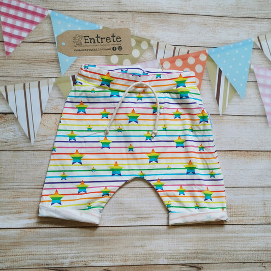 Harem shorts made using colourful rainbow stars cotton jersey, with rainbow stripes on white. Featuring elastic waist and rolled ends.