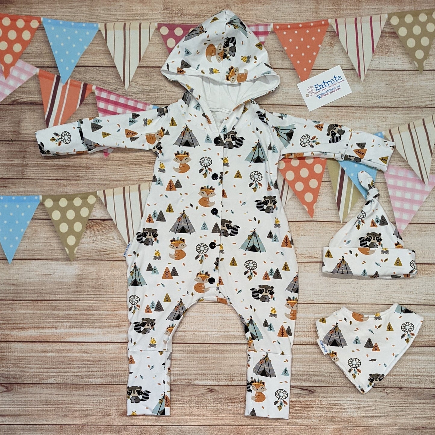 The adorable and fun foxes and raccoons hooded popper romper, featuring foxes and raccoons in native American headdresses in a tribal camp. Handmade using native American animals and white cotton jersey's. Shown with a matching bamboo bib and tie top hat.