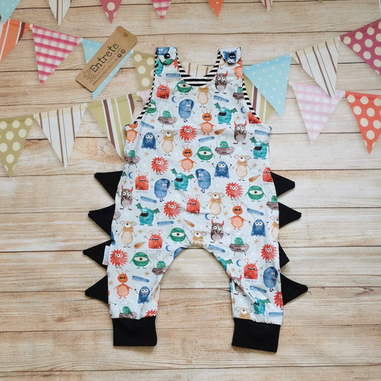 Front view of the insanely fun monster romper. Handmade from pale blue monsters cotton jersey, with black cotton jersey side detailing and cuffs and striped cotton jersey upper lining.