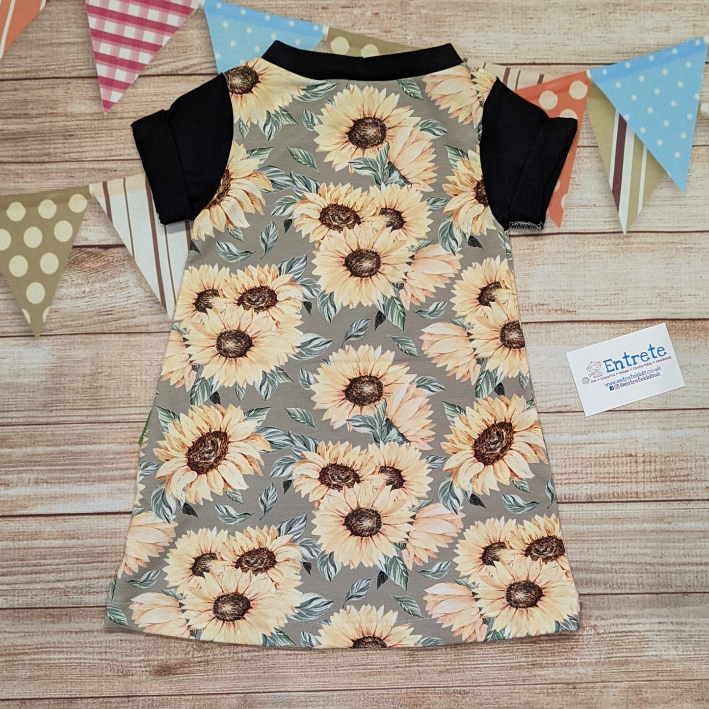 The warm sunflower T-shirt dress, handmade using sunflowers cotton French terry, black cotton jersey and black cotton ribbing. Short sleeved version shown from the rear.