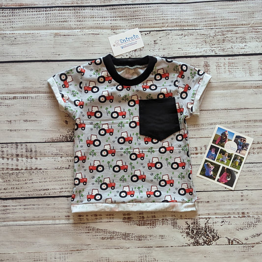 Farming fun with this red tractors on grey T-shirt, with it's contrasting front pocket. Handmade using grey tractors and black cotton jerseys' and black cotton ribbing.