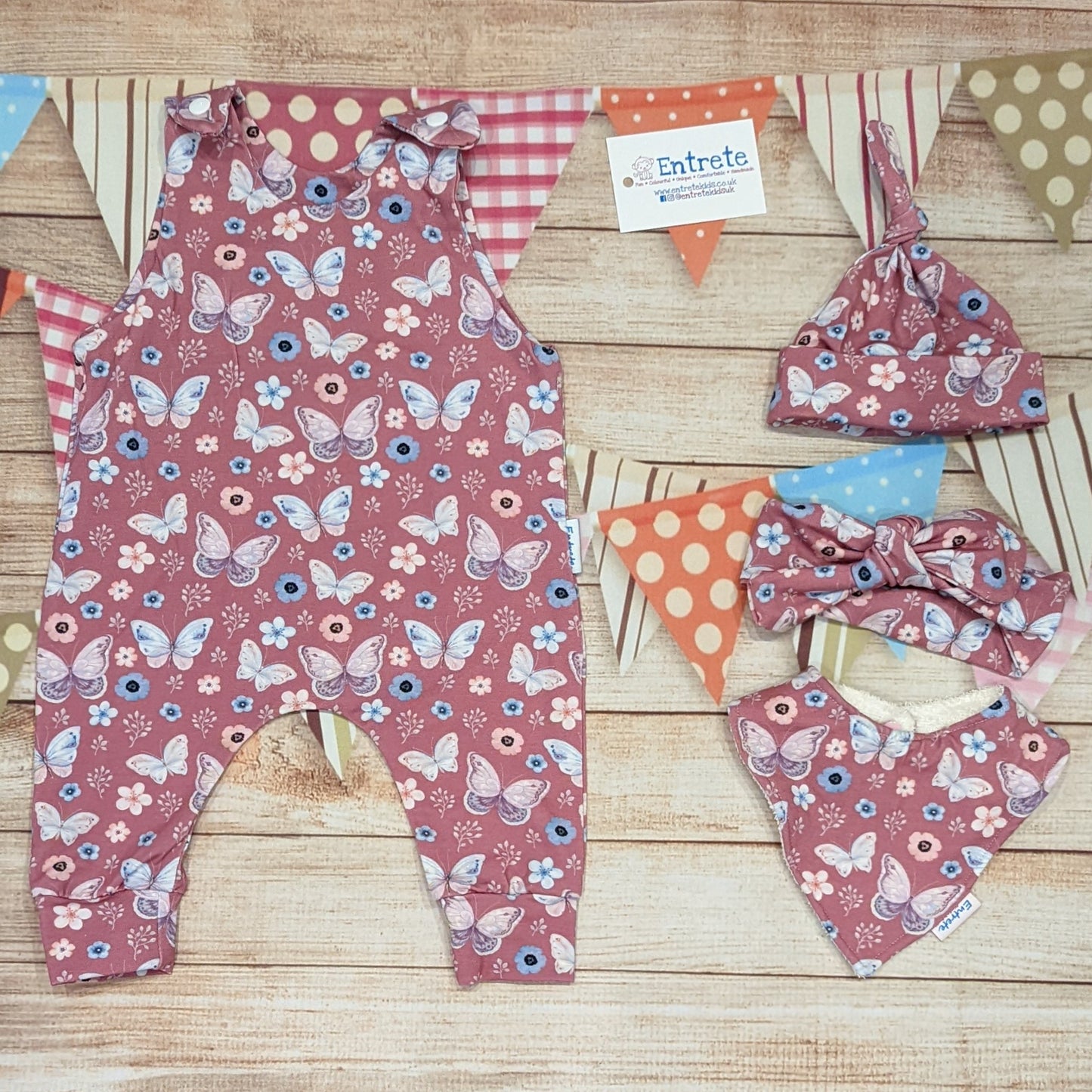 Pretty pink butterflies organic sleeveless romper. Handmade using organic pink butterflies cotton jersey. Shown with matching tie top hat, headband and bamboo bib.