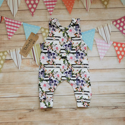 Front view of the gorgeously gothic skulls and flowers cotton jersey sleeveless romper. With shoulder popper entry and roll-able ankle cuffs.