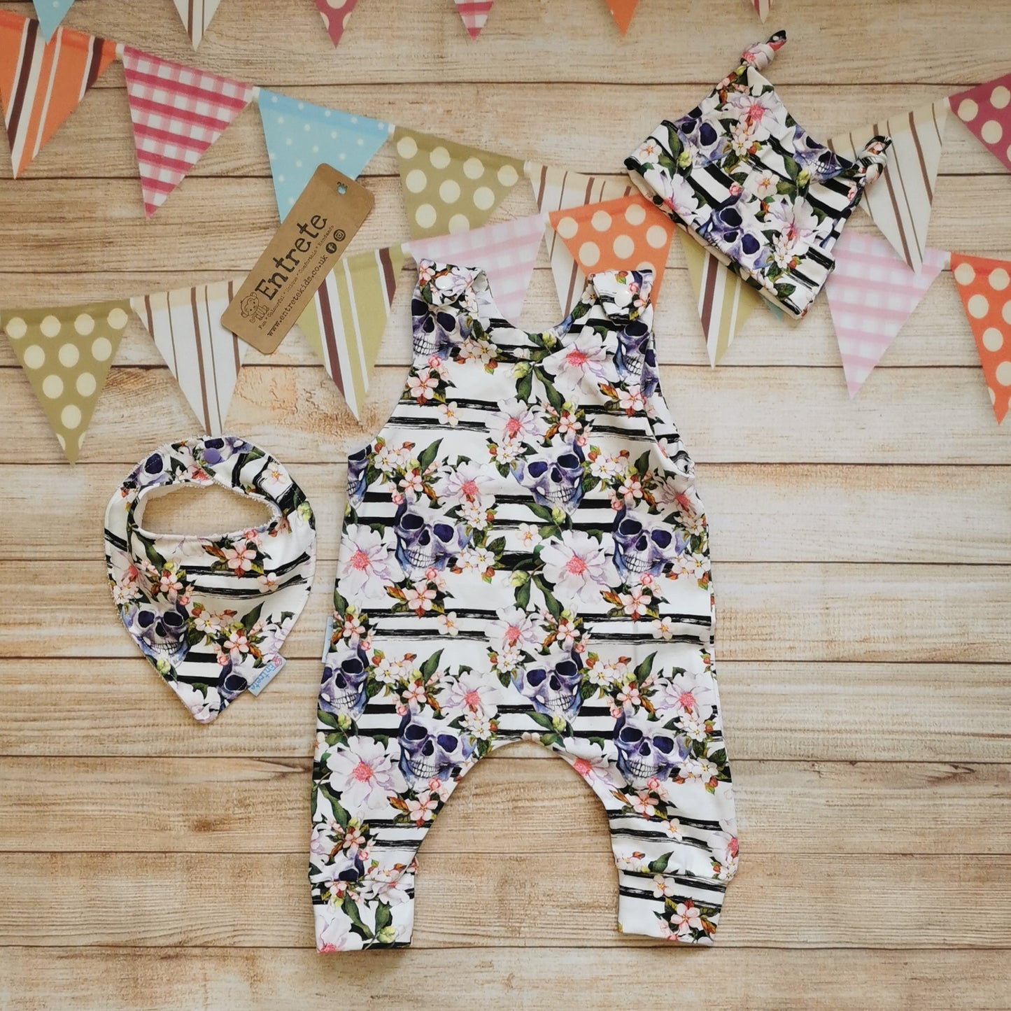 The gorgeously gothic skulls and flowers romper shown with a matching bib and tie top hat (sold separately)