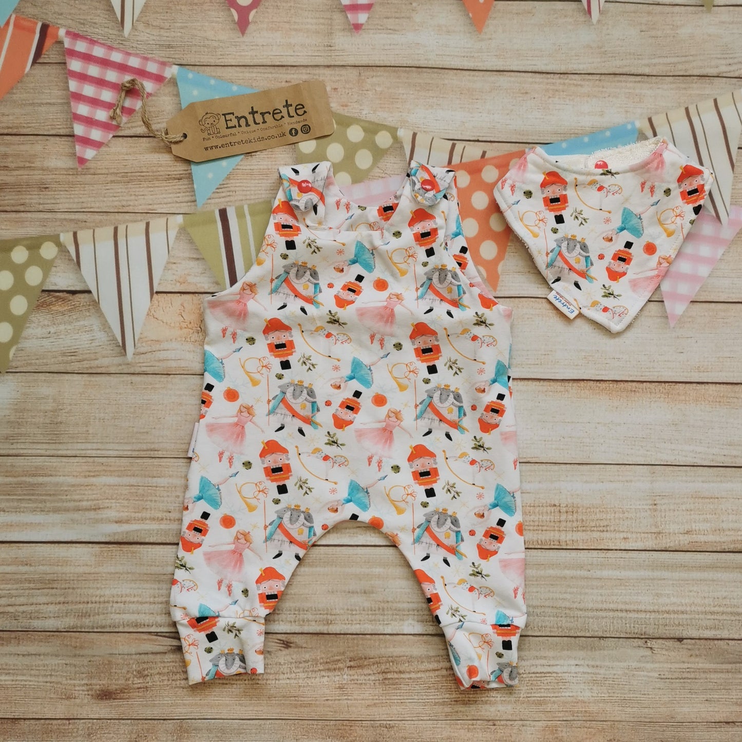 The beautiful white nutcracker romper, shown as a set with a matching bamboo bib. (sold separately)