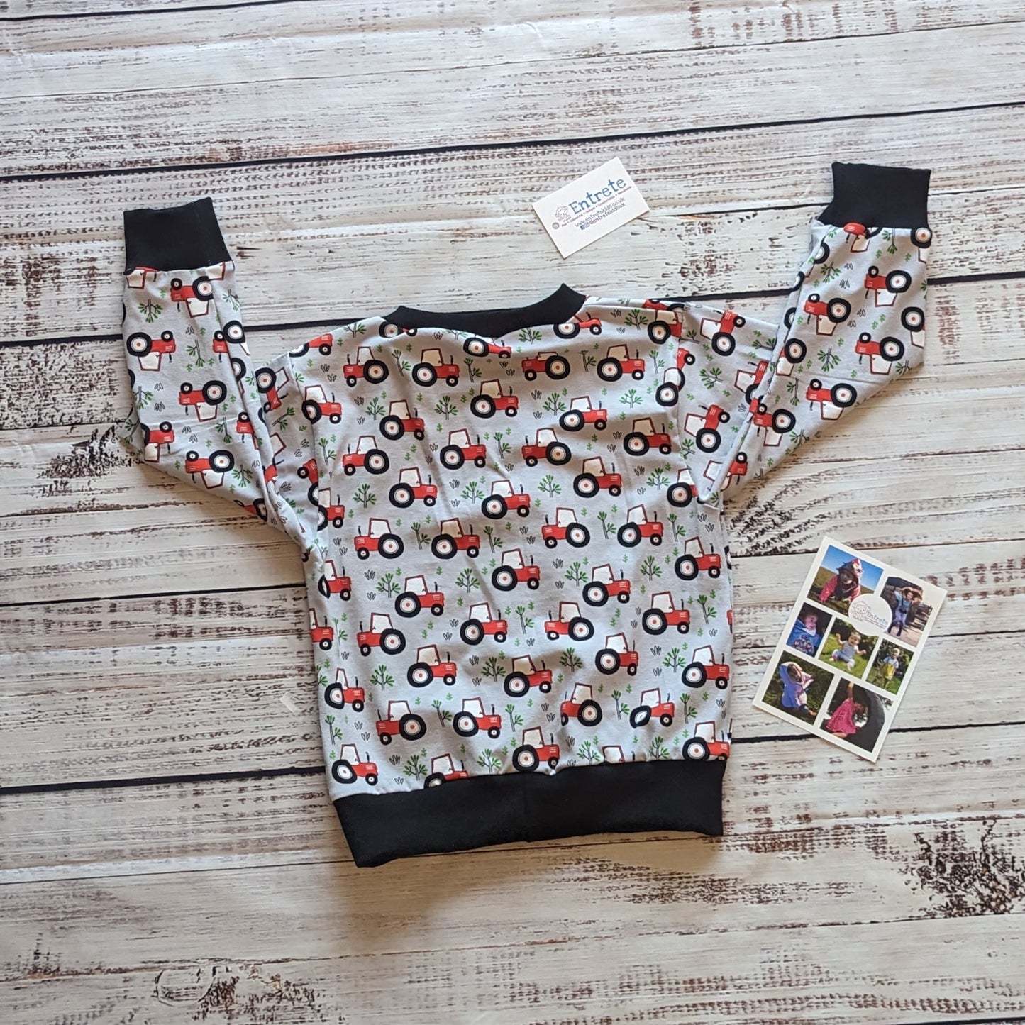 The lightweight red tractors on grey kids sweatshirt. Handmade using grey tractors cotton jersey and black cotton ribbing. Shown from the rear.