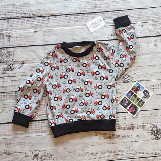 The lightweight red tractors on grey kids sweatshirt. Handmade using grey tractors cotton jersey and black cotton ribbing.