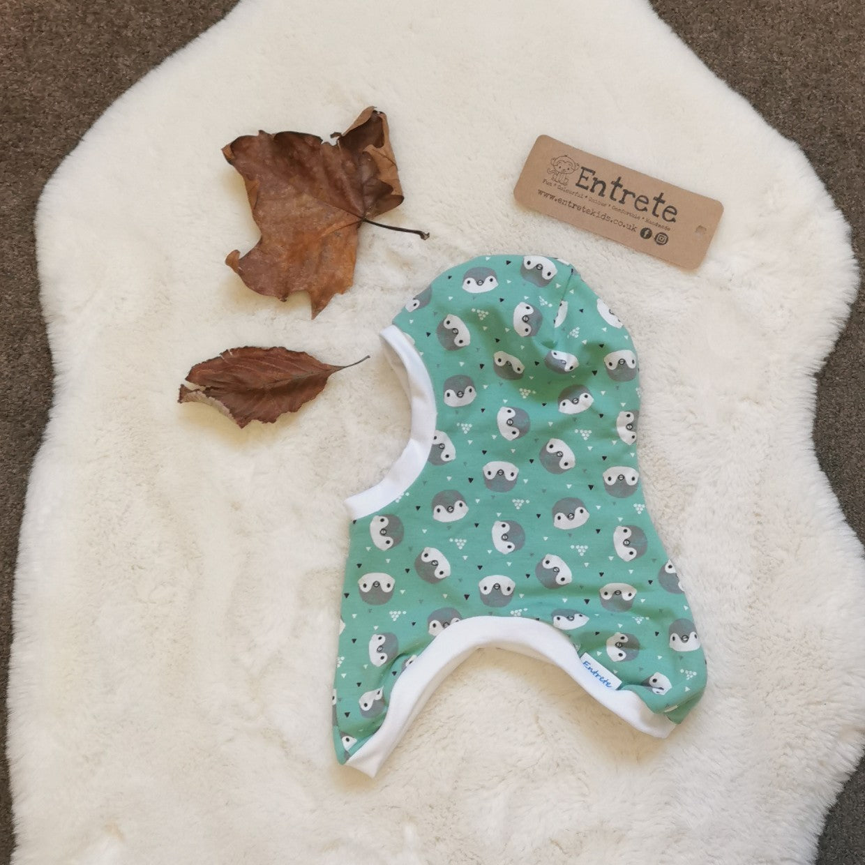 Soft and stretchy kids organic balaclava handmade using mint penguins organic cotton jersey, white organic cotton ribbing and black organic cotton jersey lining. Side view.