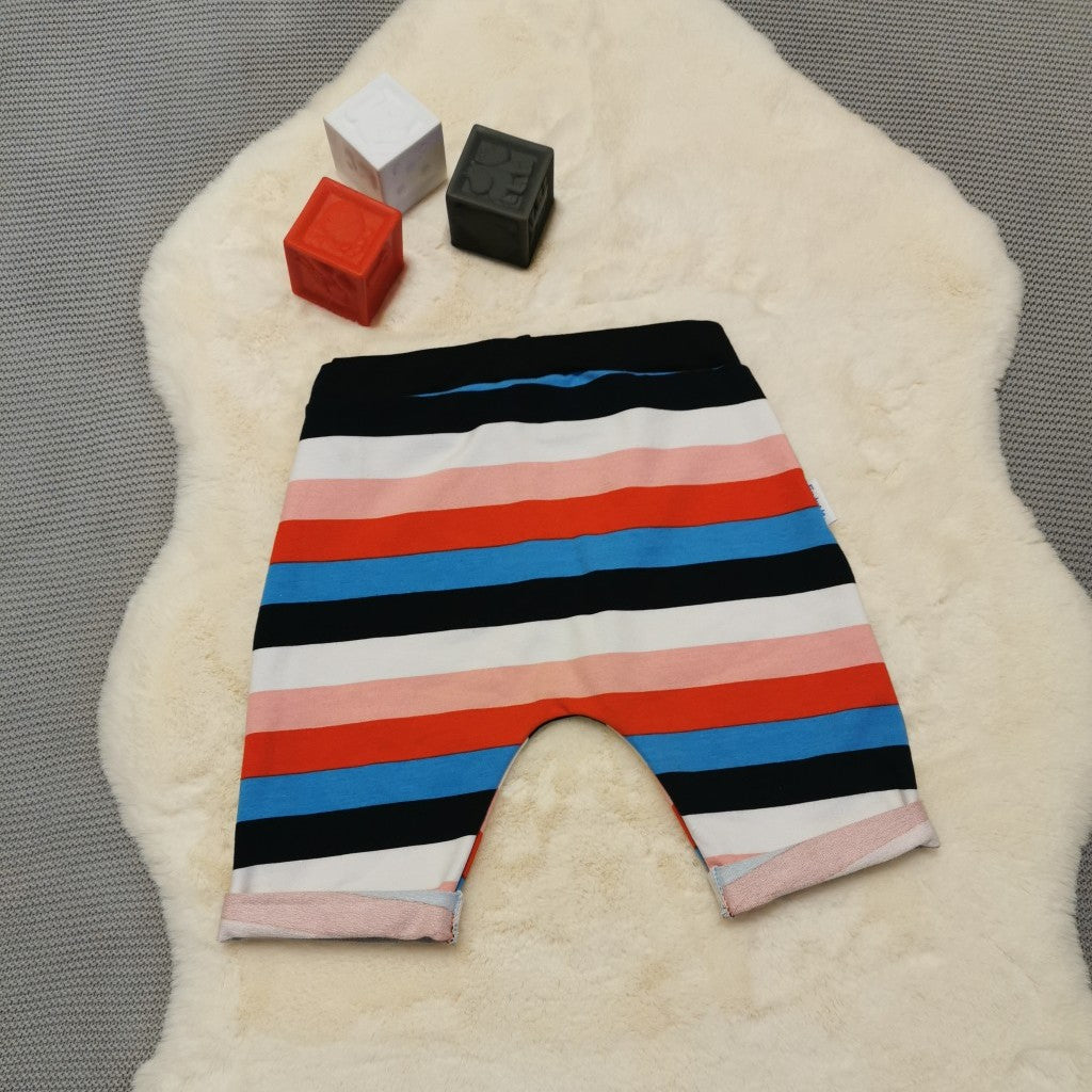 Rear view of kids harem shorts, handmade using colour striped cotton French terry and navy ribbing. Featuring elasticated waist, rolled ends and lowered crotch.