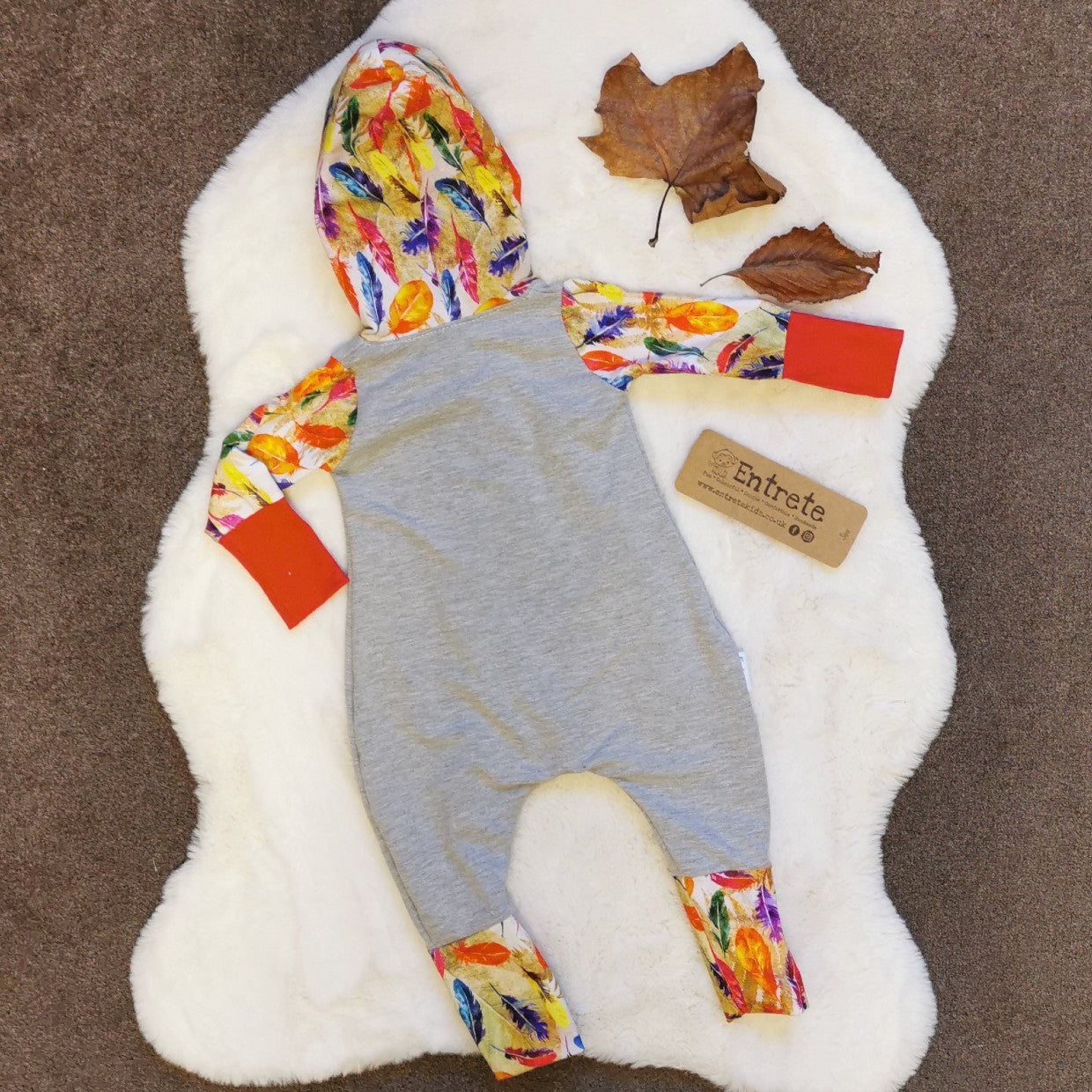 Rear of the warm, vibrant feathers romper. Handmade using grey cotton sweat fabric, feathers and orange cotton jerseys'.