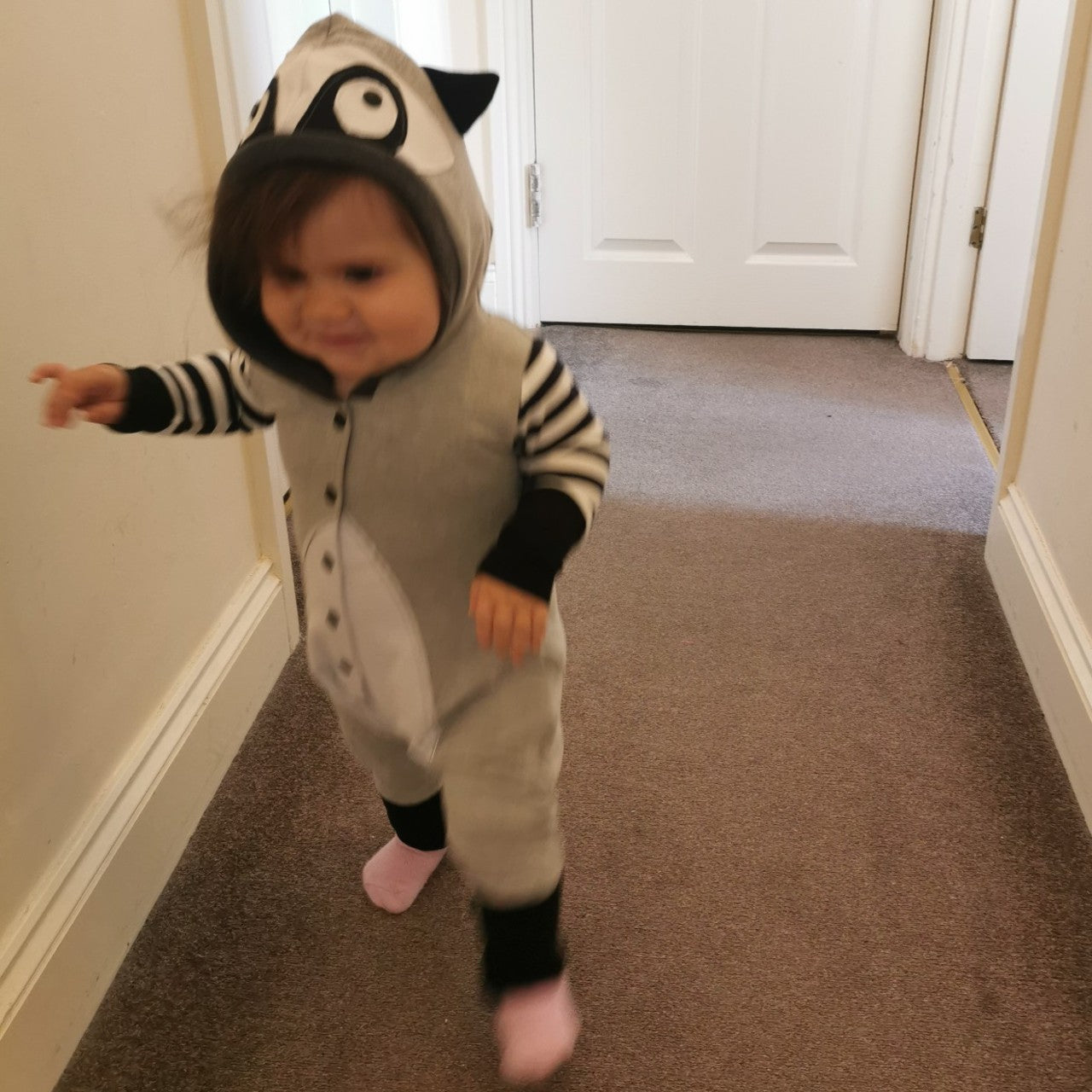 Sophie can't stop smiling in her Raccoon Romper.