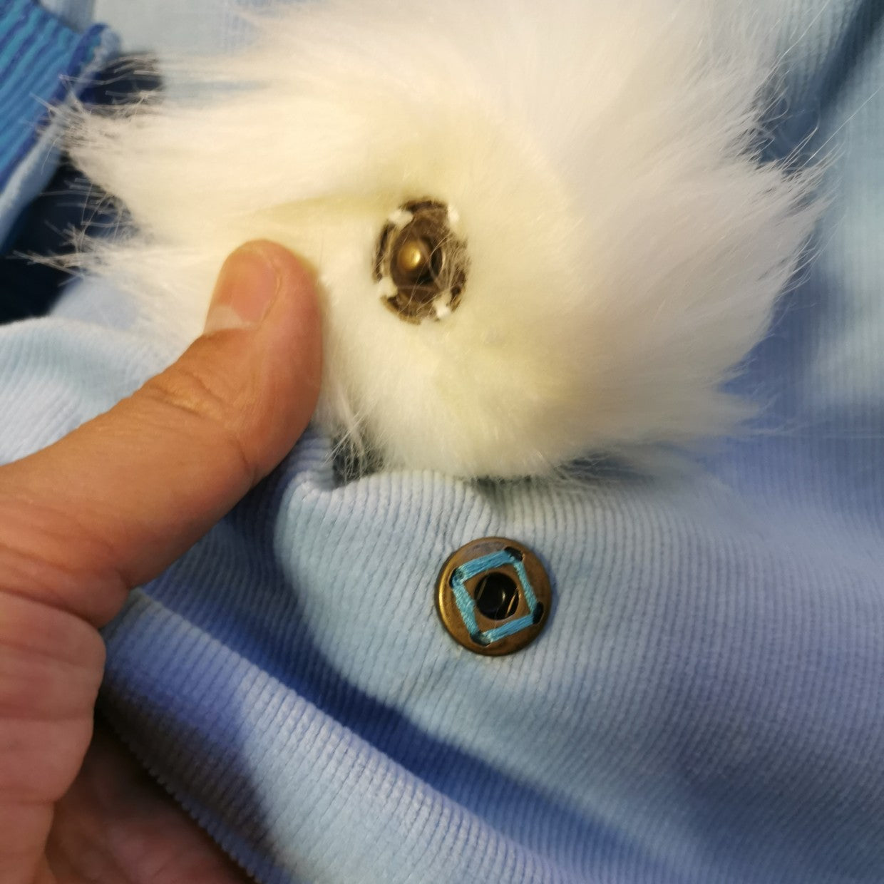 Close up of popper fastener used to attach or remove pom pom bunny tail.
