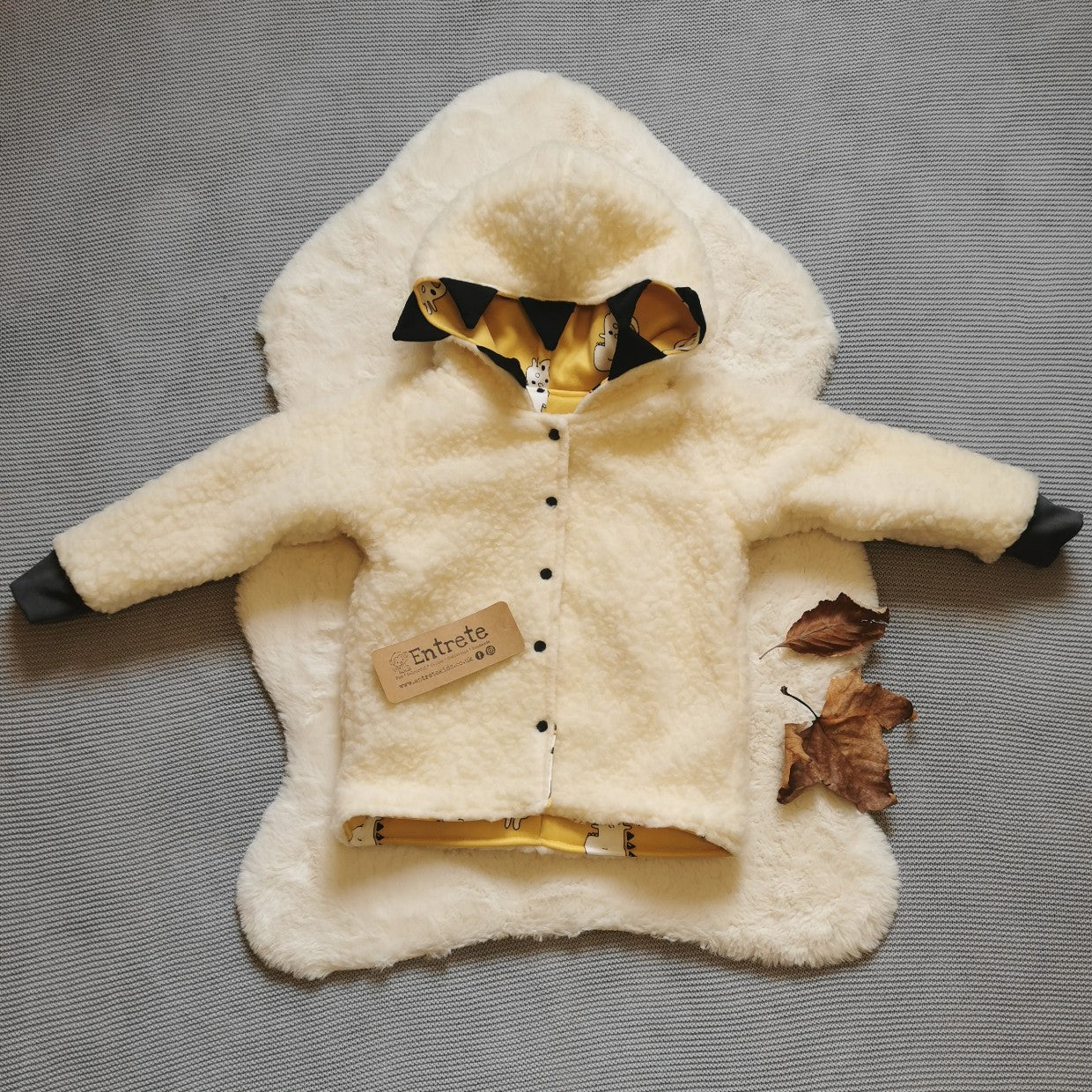 Reverse side of the epic mustard dinosaur coat. Handmade in stylish and warm sherpa fur with graphite cotton ribbing.