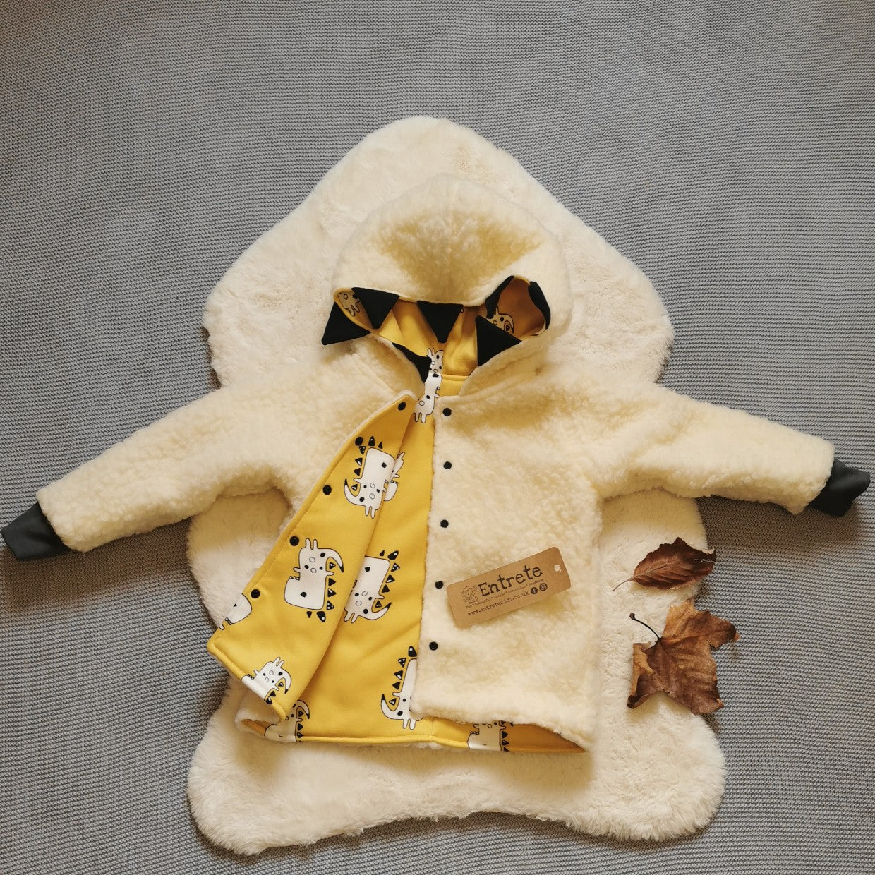Reverse side of the epic mustard dinosaur coat. Handmade in stylish and warm sherpa fur with graphite cotton ribbing.