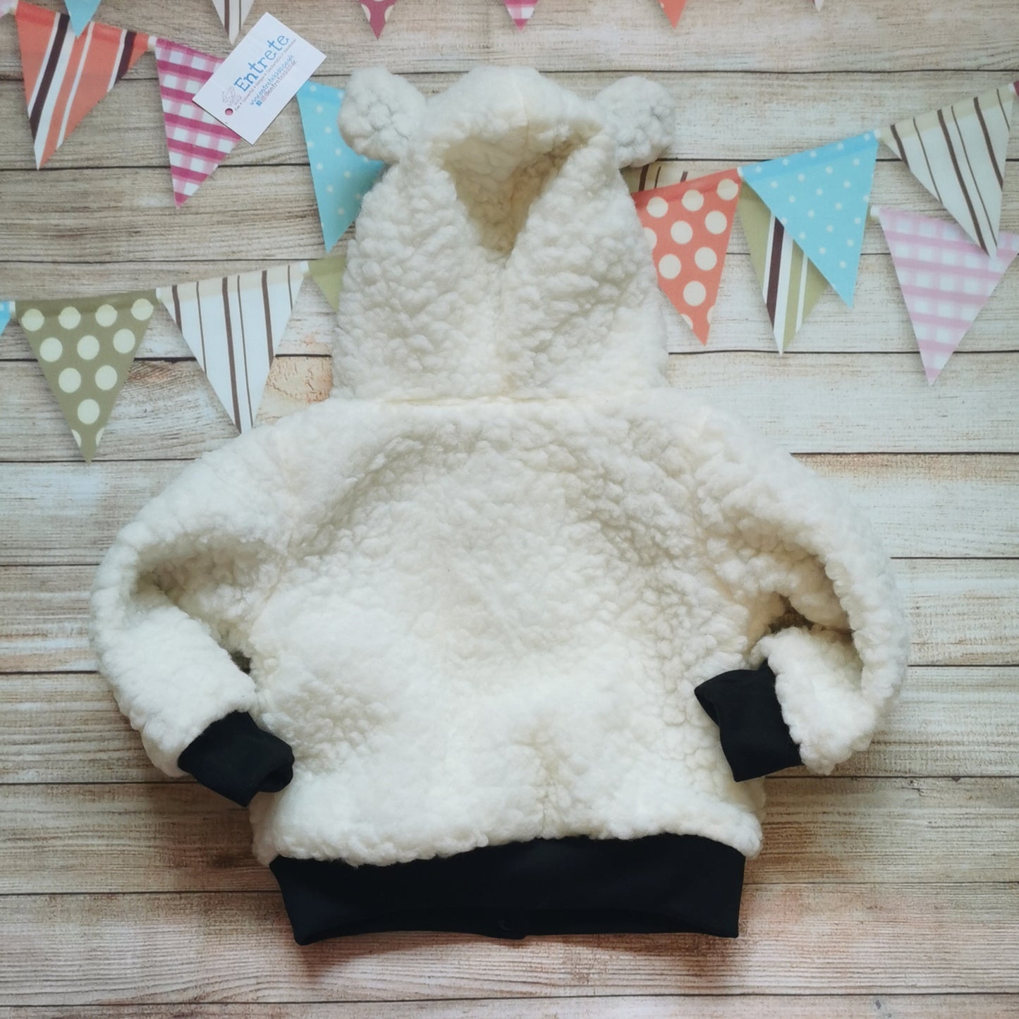 Rear view of the adorable polar bear hoodie. Handmade using warm sherpa fur and black cotton ribbing, with festive dusty blue polar bears cotton jersey on the reverse.