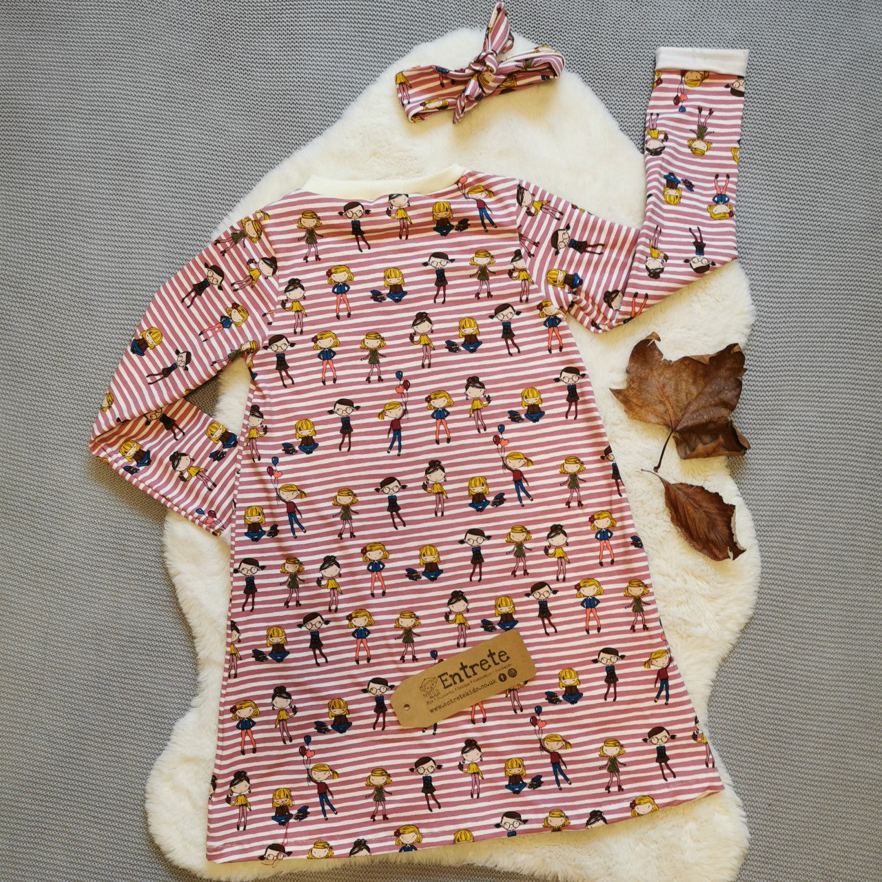 The fun girls on pink stripes T-Shirt dress, with it's popper free pullover design. Handmade using girls on pink stripes cotton jersey and cream cotton ribbing. Long sleeved version shown from the rear with a matching headband.