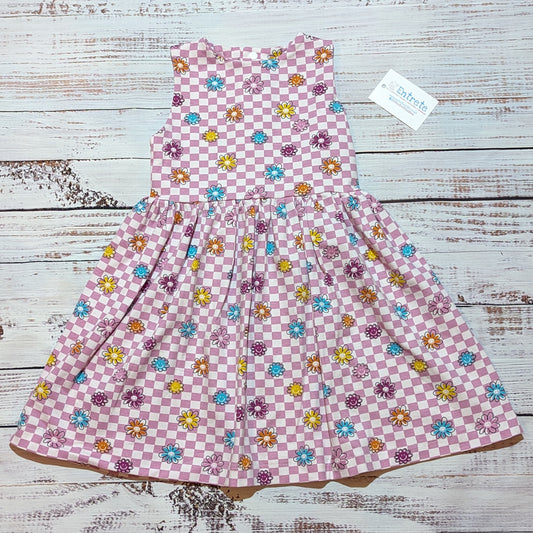 The adorable pink checked happy flowers dress. handmade in soft and comfy cotton jersey with a smiling flowers print. Shown as a sleeveless dress.
