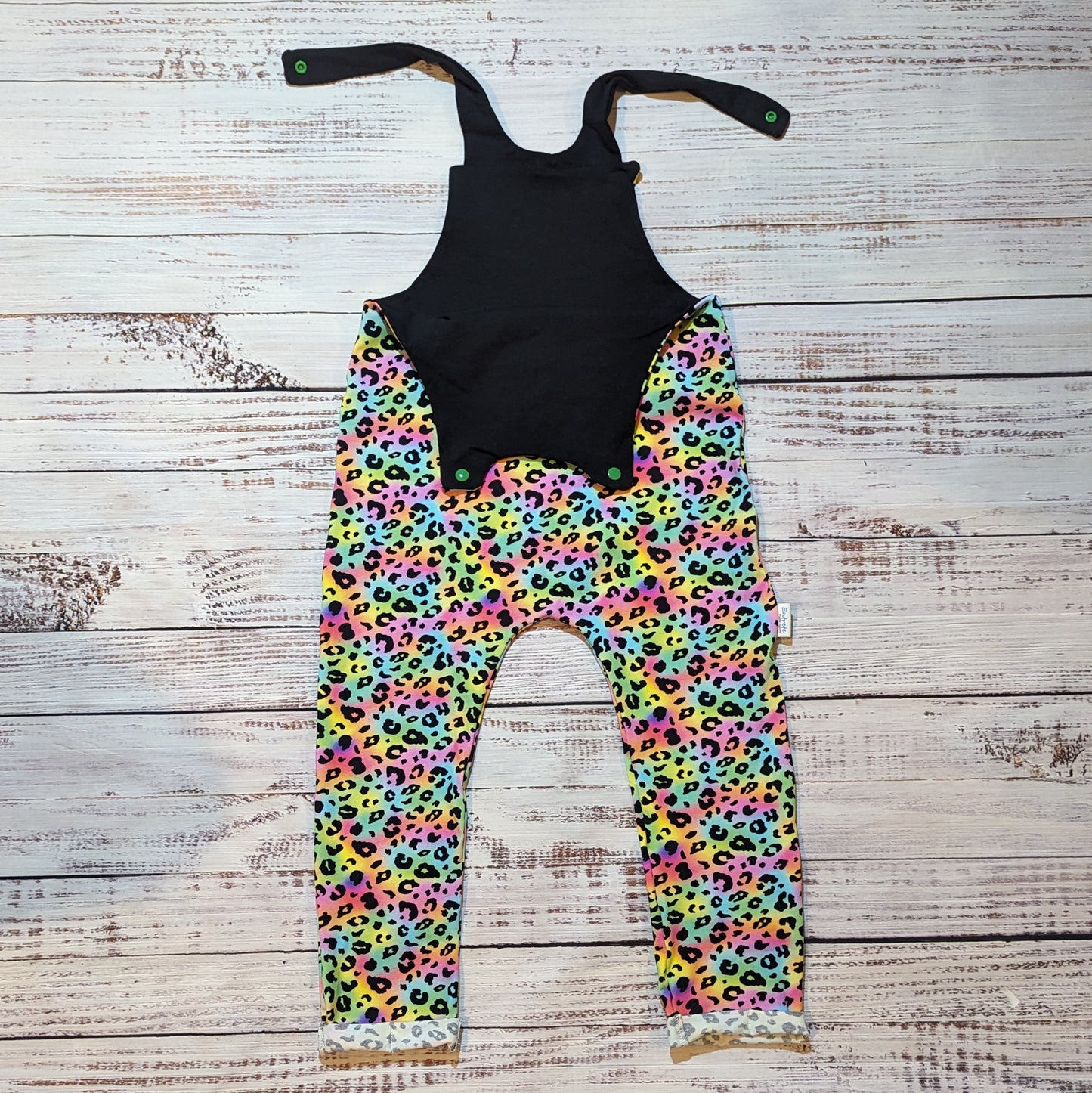 Colourful child and toddler dungarees. Handmade using soft and comfortable rainbow leopard print cotton jersey. With popper Shoulder straps open. 