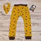 Adorably fun mustard Vikings harem joggers. Lovingly handmade using mustard Vikings and chocolate cotton jersey's. Shown from the back with a matching bamboo bib.