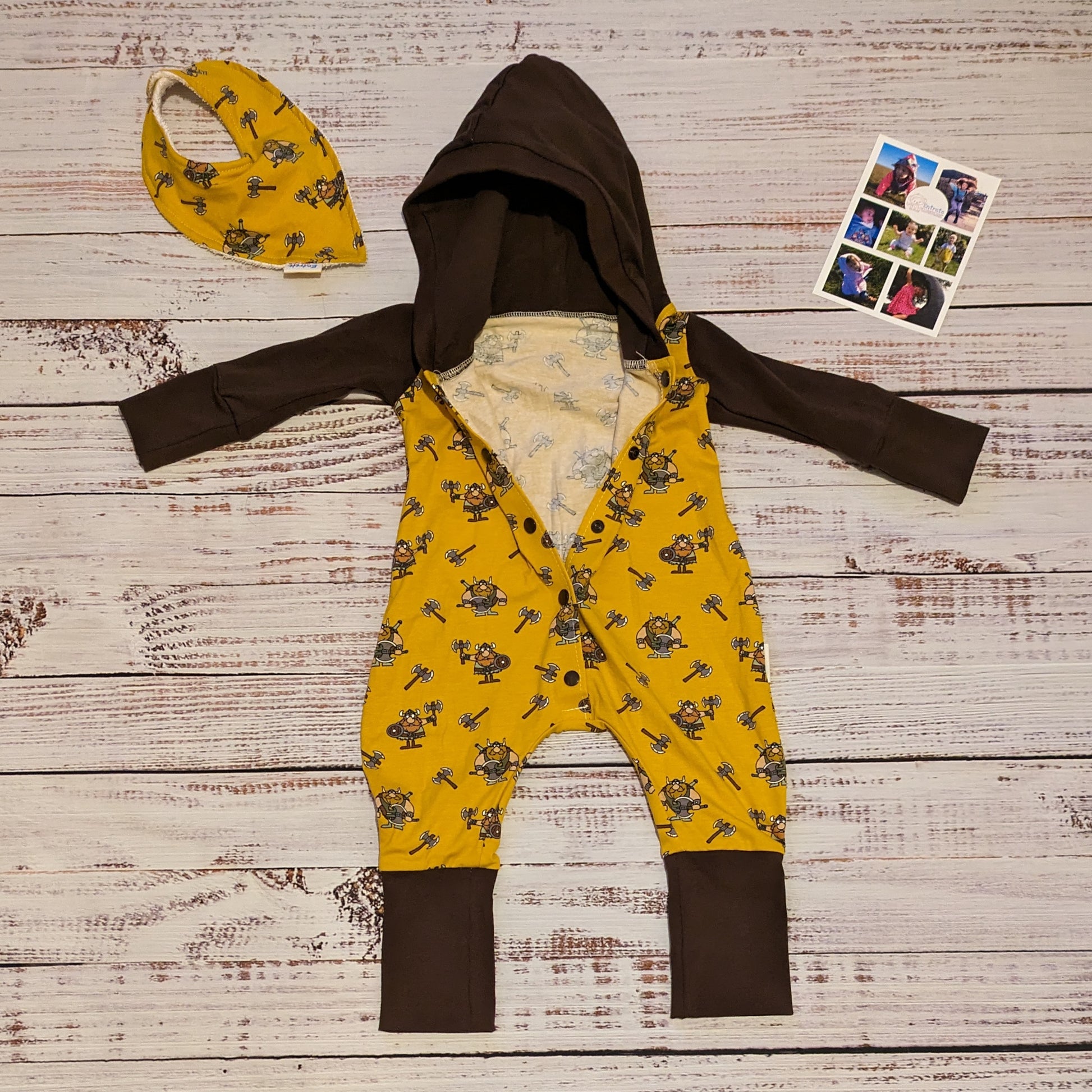 The fun and adorable mustard Vikings, hooded popper romper. Shown with long sleeves and the front popper entry half open, with a matching bamboo bib. Lovingly handmade in mustard Vikings and chocolate cotton jersey's.