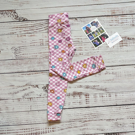 Soft, stretchy and fun. The pink checked happy flowers women's leggings. With a smiling flowers print.