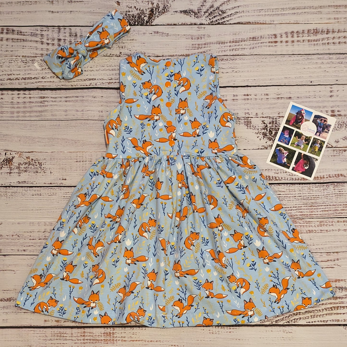 The fantastic Sky blue foxes girls dress, shown as a sleeveless dress from the back with a matching headband. Handmade using soft and comfy sky blue foxes cotton jersey.