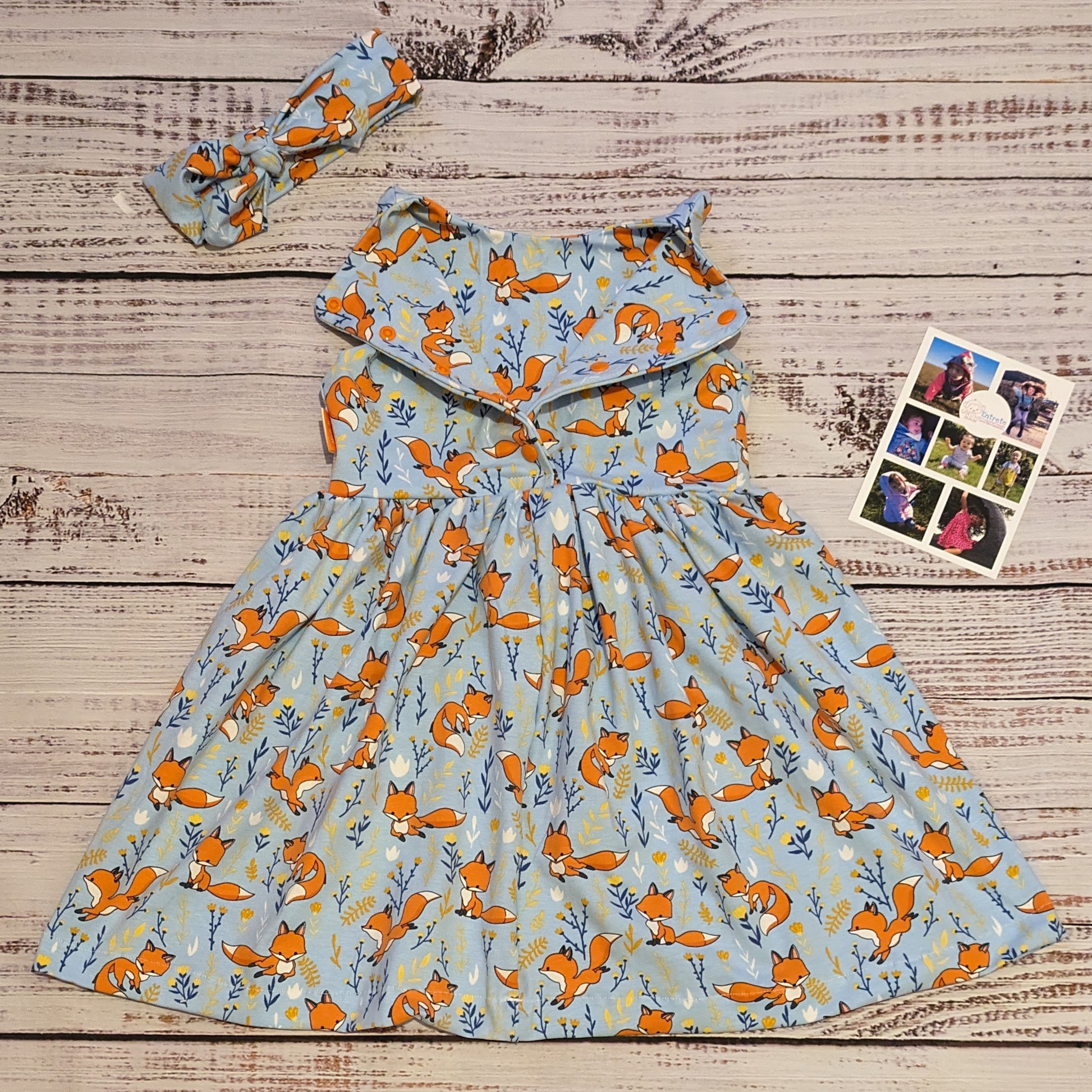 The fantastic Sky blue foxes girls dress, shown as a sleeveless dress with the rear popper entry open and a matching headband. Handmade using soft and comfy sky blue foxes cotton jersey.
