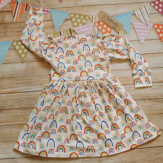 Front of Girls & toddlers back popper dress, handmade using the fun white colourful rainbows and hearts cotton jersey.