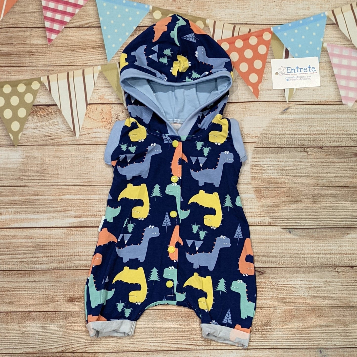 Fun and colourful dinosaurs hooded bummie romper. Handmade using blue dinosaurs and sky blue cotton jersey's with light blue cotton ribbing.