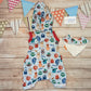 The insanely fun monsters hooded bummie romper, just what your little monster needs this summer! Handmade using pale blue monsters organic cotton Jersey, royal blue cotton jersey and red cotton ribbing. Shown from the rear and with a matching bamboo bib.