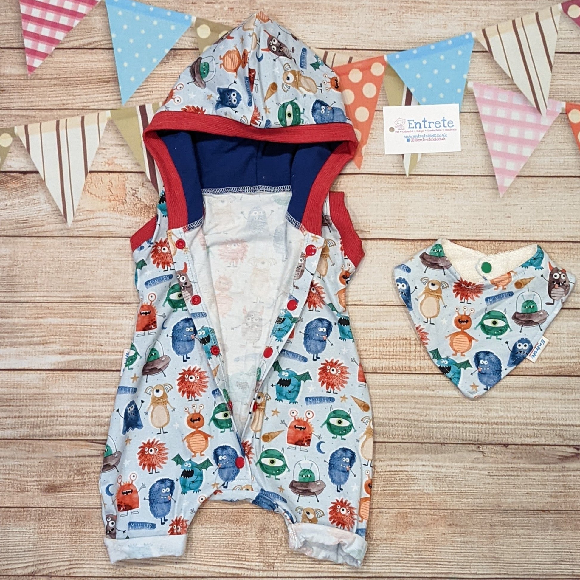 The insanely fun monsters hooded bummie romper, just what your little monster needs this summer! Handmade using pale blue monsters organic cotton Jersey, royal blue cotton jersey and red cotton ribbing. Shown with the front popper entry open and with a matching bamboo bib.