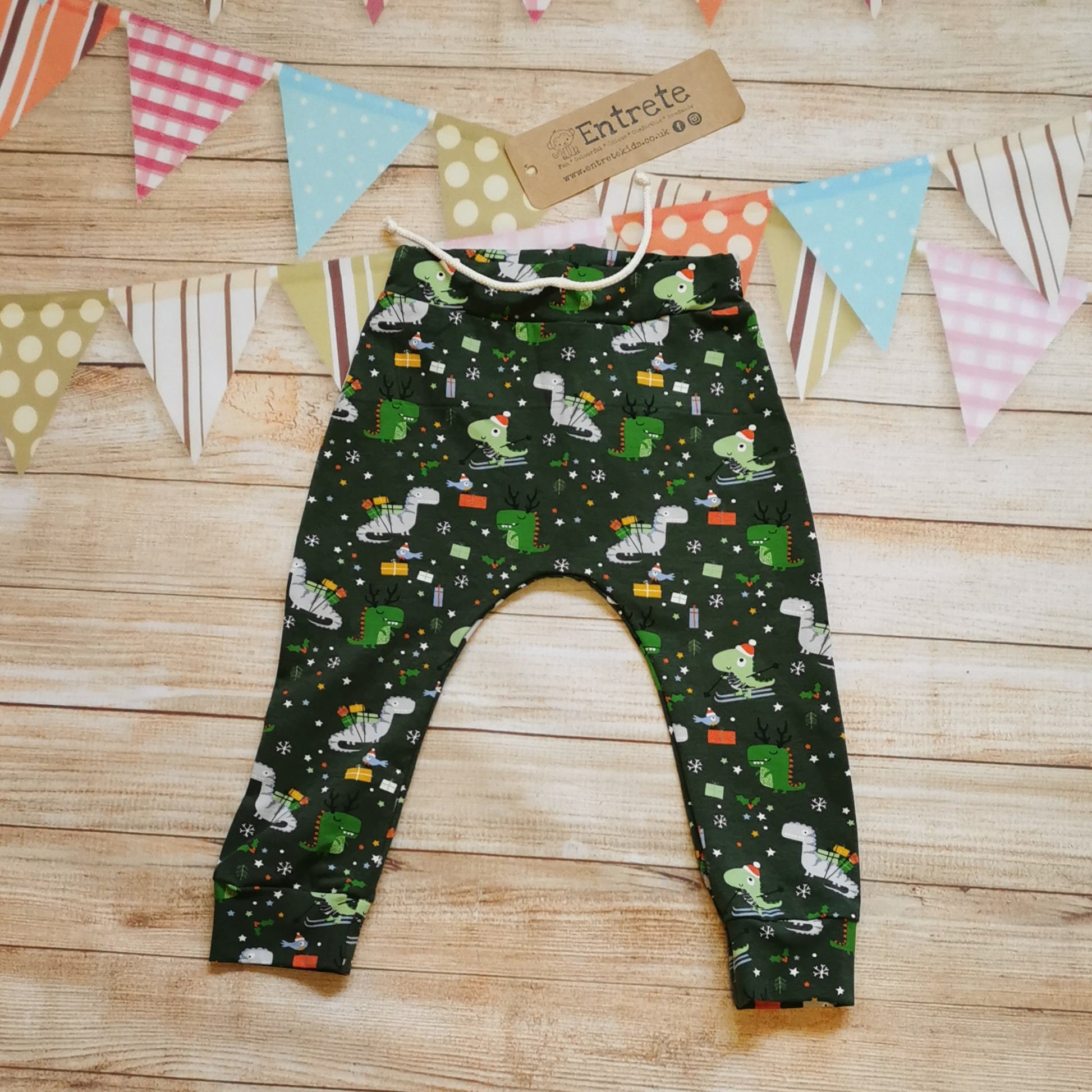 Harem joggers with elasticated waist, dropped crotch and roll-able ankle cuffs. Handmade in dark green festasaurus cotton jersey. Perfect for your little dinosaur fanatic!