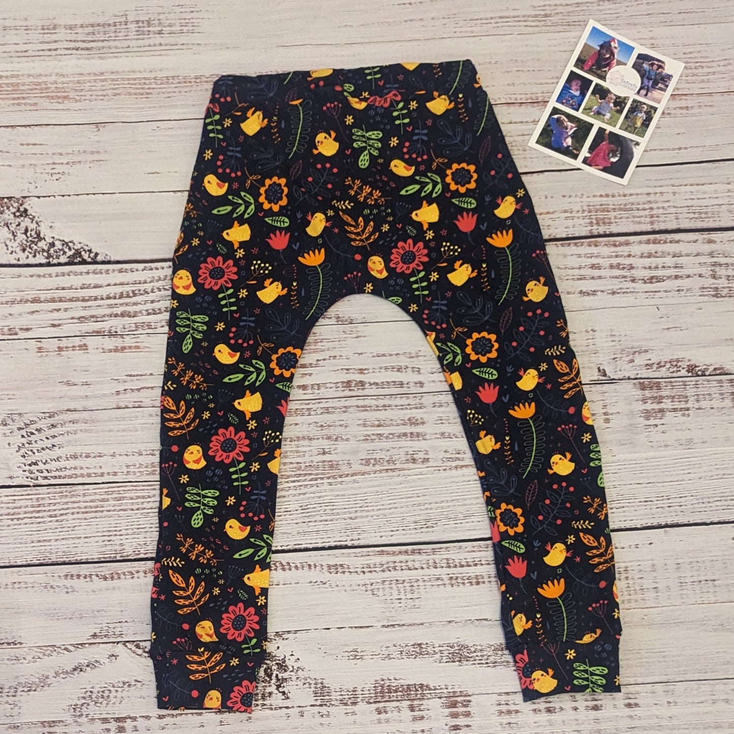 Vibrant and fun flowery chicks kids harem joggers. Handmade using navy chicks cotton jersey. Shown from the rear.