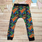 The insanely fun skateboarding dinosaurs harem joggers, handmade using street dino cotton French terry and black cotton ribbing. Shown from the rear.