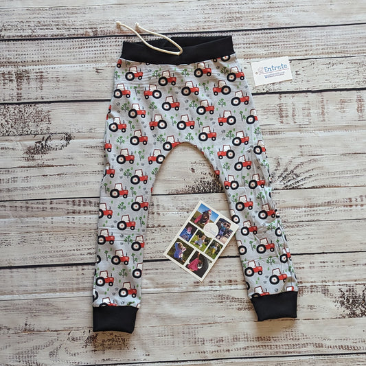 Fun red tractors on grey kids harem joggers. Handmade using grey tractors cotton jersey and black cotton ribbing.