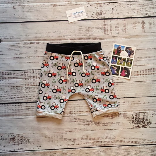 Fun red tractors on grey kids harem shorts. Handmade using grey tractors cotton jersey and black cotton ribbing.