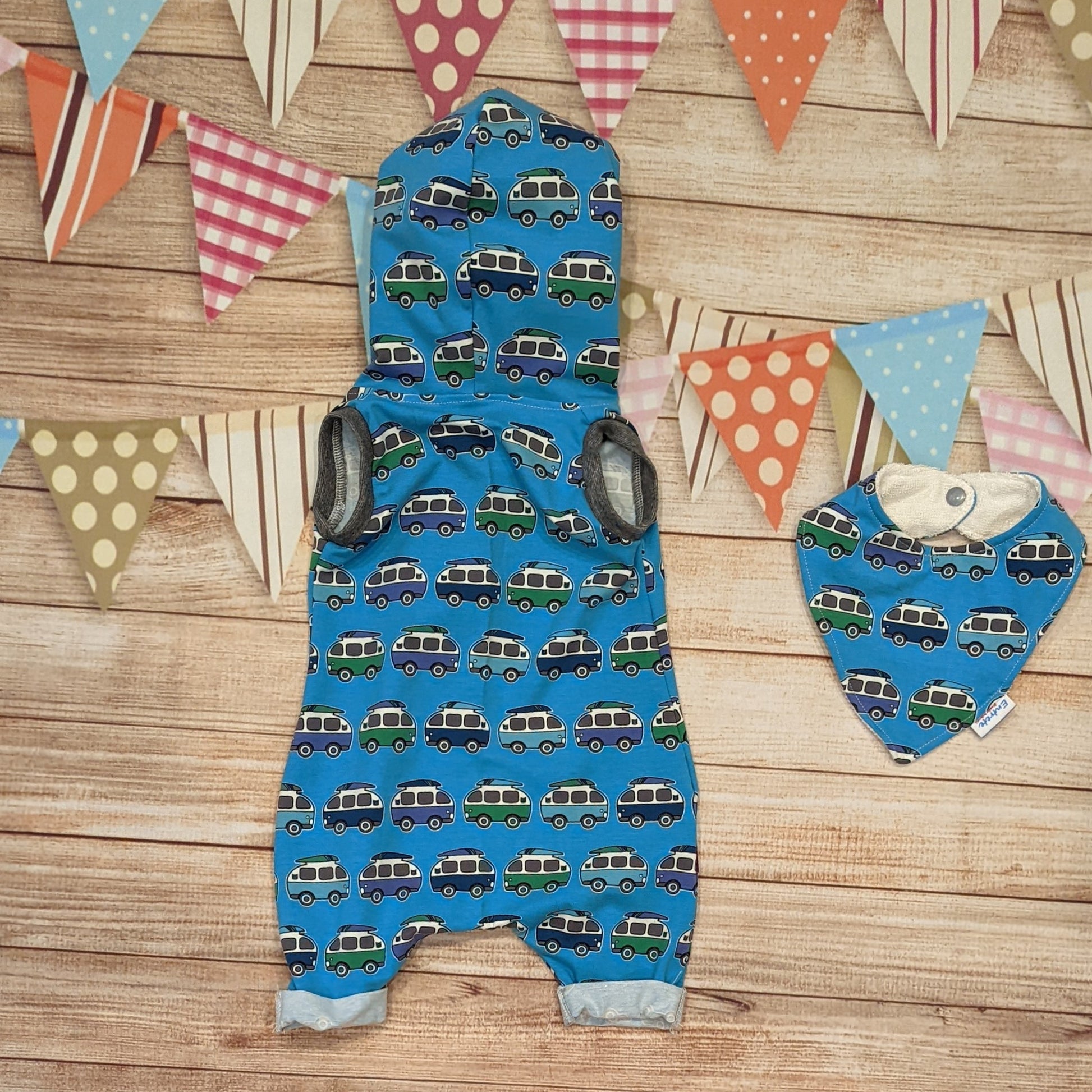 The epic blue surf campervan bummie romper. Handmade using blue surf campervan and monochrome striped cotton jersey's with graphite cotton ribbing. Shown from the rear and with a matching bamboo bib.