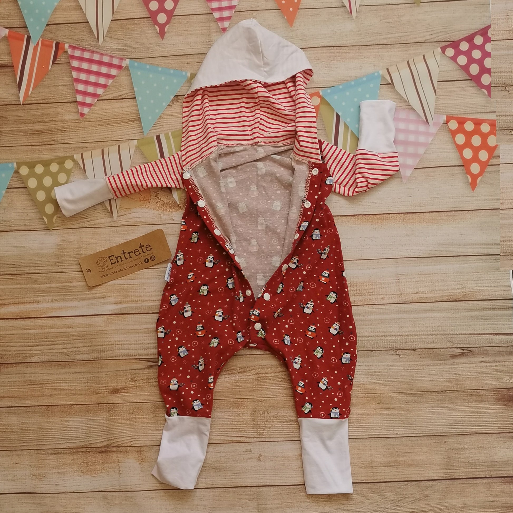 The epic christmas penguins hooded popper romper. Handmade using red penguins, red striped and white cotton jerseys for the perfect Christmas loungewear! Showing the popper entry.