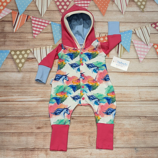 The colourful unicorns on white hooded romper. Handmade using colourful unicorns on white, fuchsia and sky blue cotton jerseys' with cream cotton ribbing.