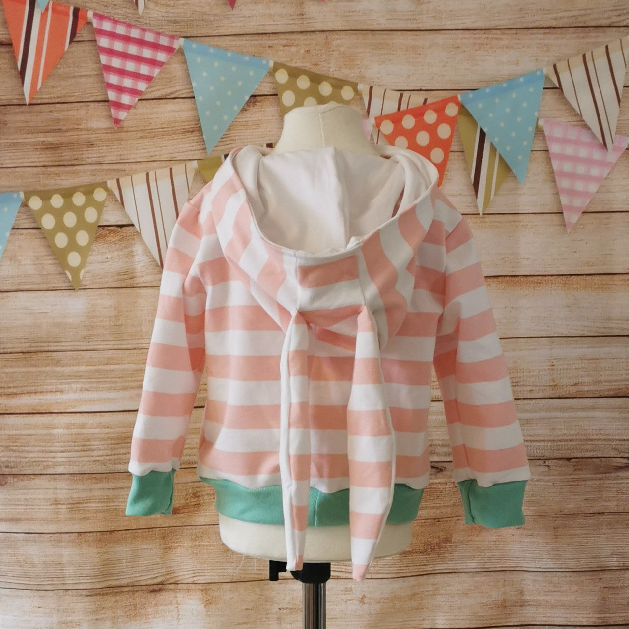 The lightweight pink striped bunny hoodie, with fun bunny ears on the hood. Handmade using pink striped cotton French terry, white cotton jersey and mint cotton ribbing. Shown from the rear.
