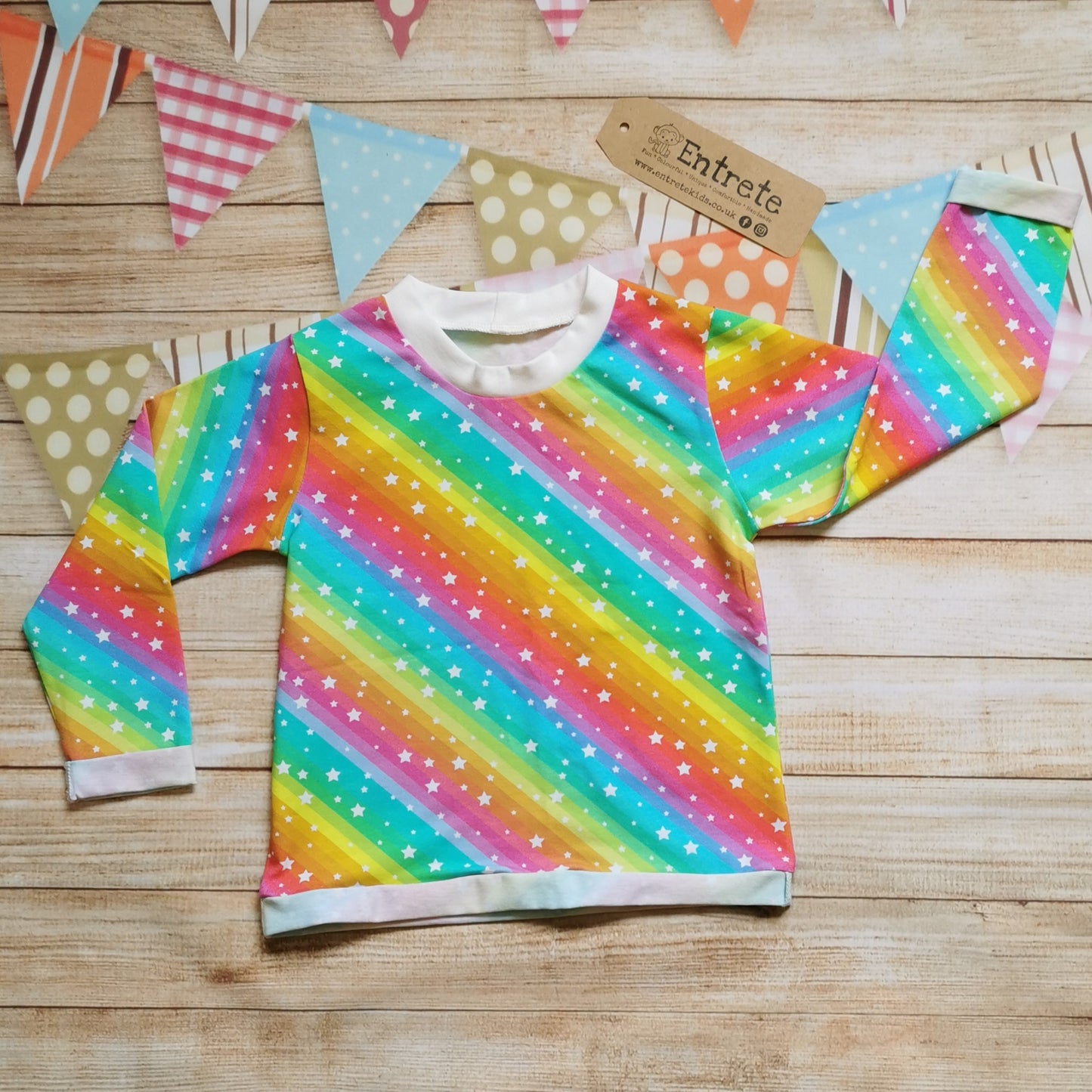 Long sleeve Tee with rolled cuffs and waist. Handmade in the vivid bright rainbow stars cotton jersey with a cream ribbing neck.