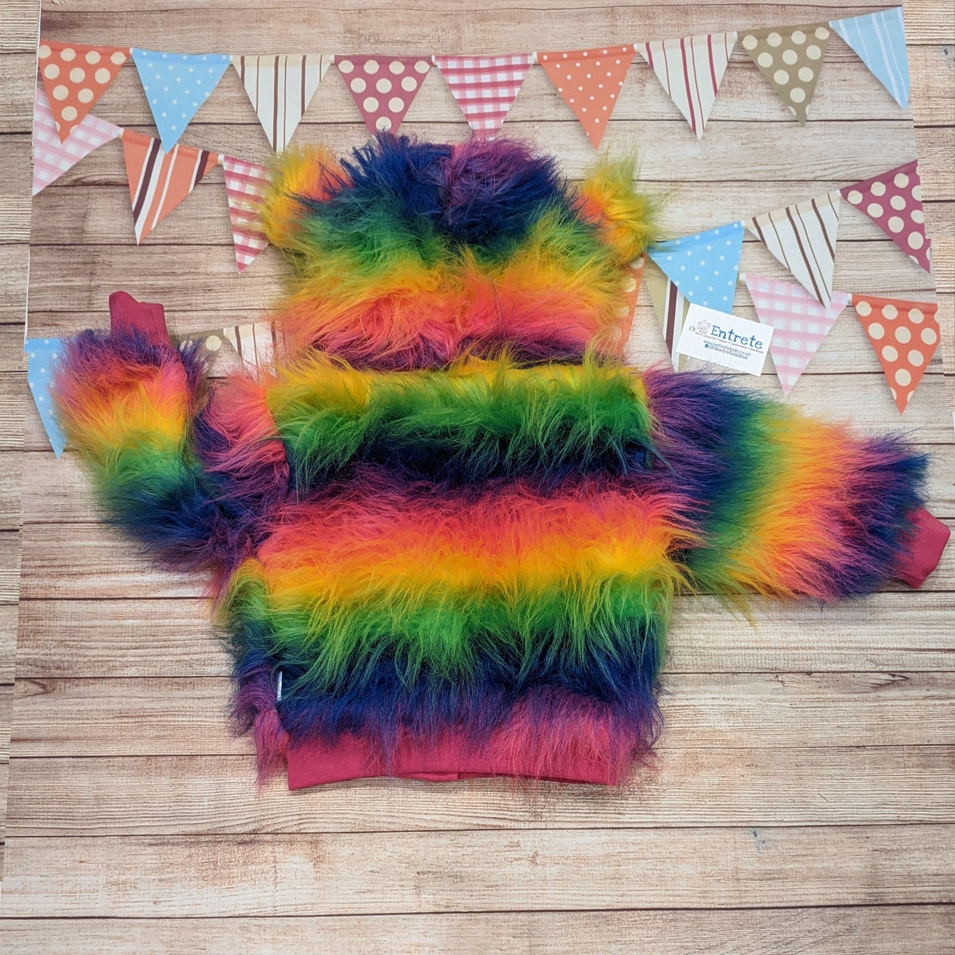 The colourful rainbow bear reversible hoodie. Handmade from rainbow long hair faux fur and fuchsia cotton ribbing, with royal blue cotton jersey on the reverse. Shown from the rear.