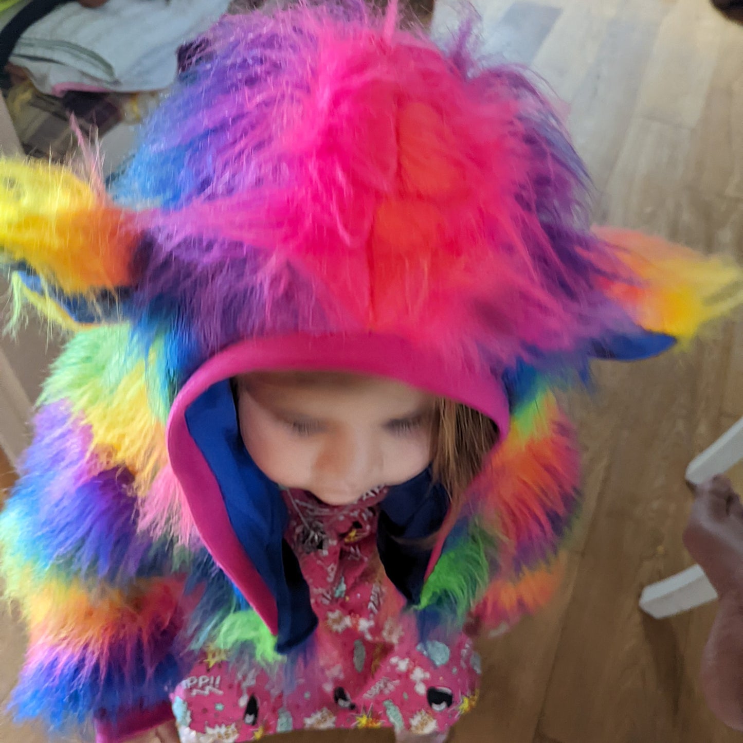 Sophie in her rainbow bear reversible hoodie, showing the hood detail with fun bear ears and fuchsia ribbing.