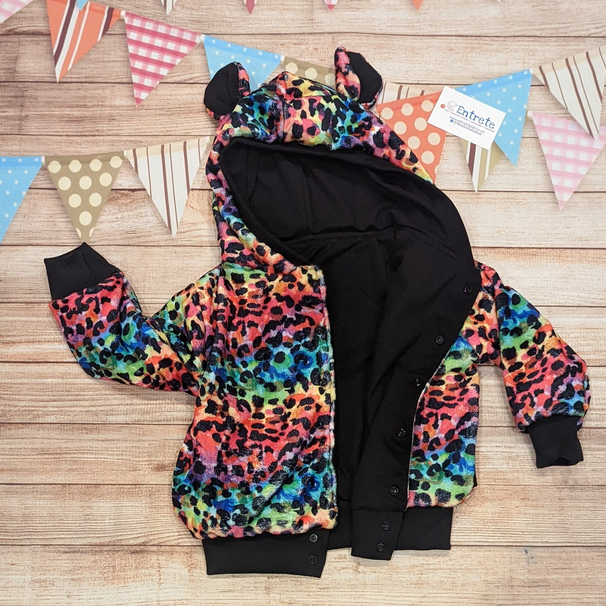 The colourful and warm rainbow leopard hoodie. Handmade using rainbow leopard print bubs fleece, black cotton ribbing, with a black cotton jersey reverse. Shown with front popper entry open.