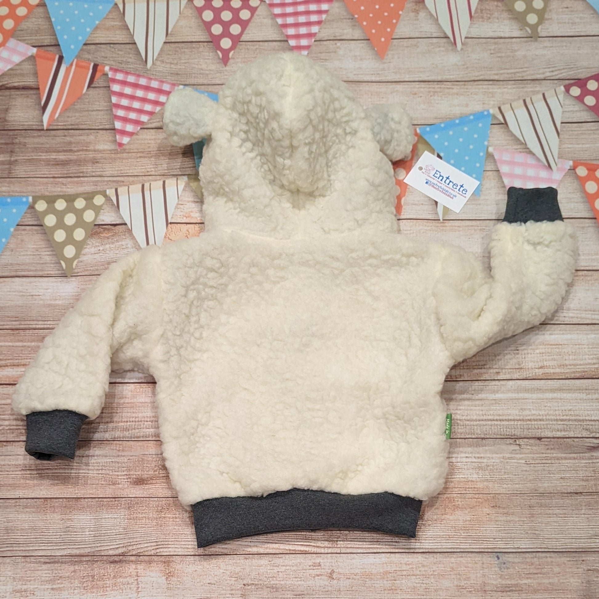 The adorable sheep hoodie handmade using sherpa fur and graphite cotton ribbing, with adorable and fun checkboard farm animals cotton jersey on the reverse. Shown from the rear.