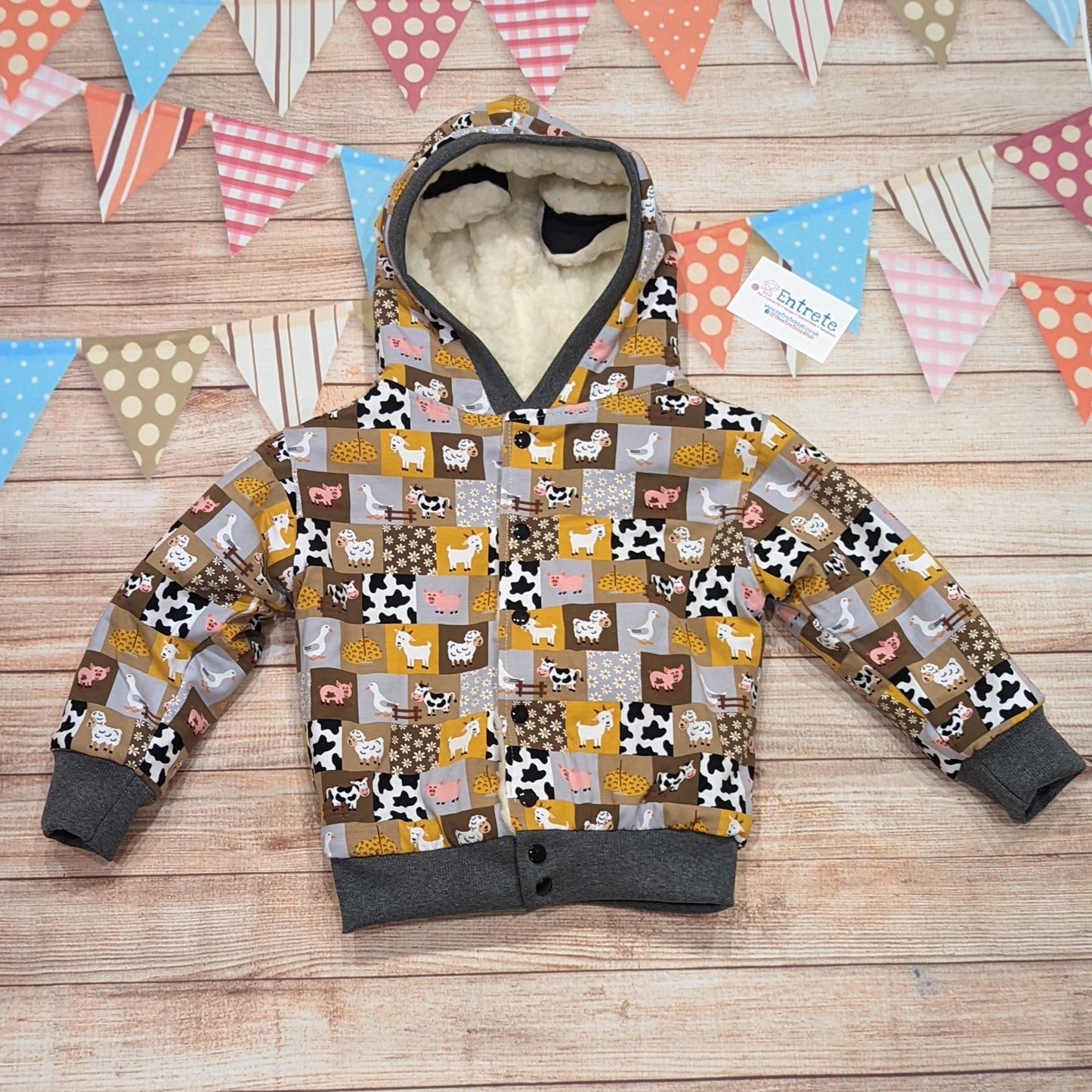 The adorable sheep hoodie handmade using sherpa fur and graphite cotton ribbing, with adorable and fun checkboard farm animals cotton jersey on the reverse. Showing the reverse farm animals hoodie.